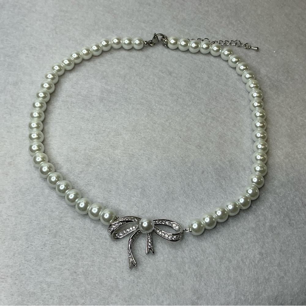 Beautiful pearl choker necklace featuring a pave-set bow pendant